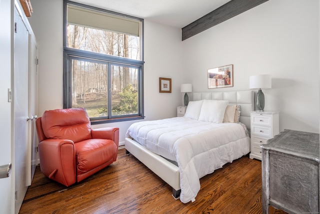 bedroom featuring dark wood-style floors and beamed ceiling