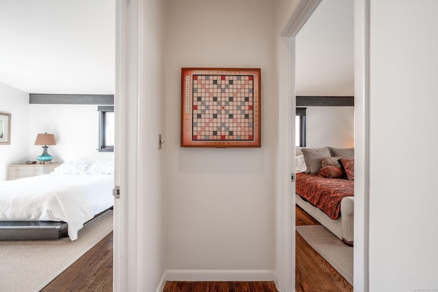 corridor featuring baseboards and wood finished floors