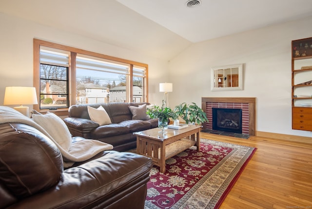 93 Lyman Rd, West Hartford, CT 06117 - living area with a fireplace, light wood-style floors, lofted ceiling, and visible vents