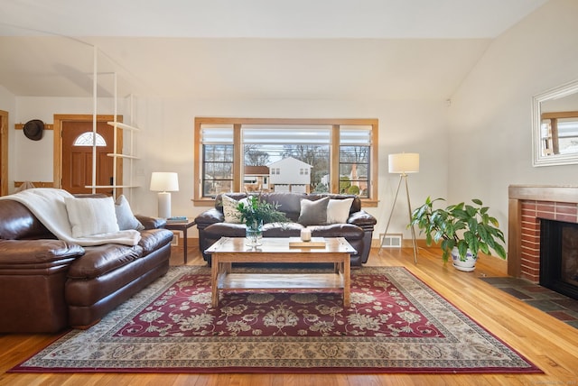 93 Lyman Rd, West Hartford, CT 06117 - living room featuring a brick fireplace, wood finished floors, visible vents, and lofted ceiling