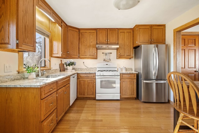 93 Lyman Rd, West Hartford, CT 06117 - kitchen featuring brown cabinetry, under cabinet range hood, a sink, and white appliances