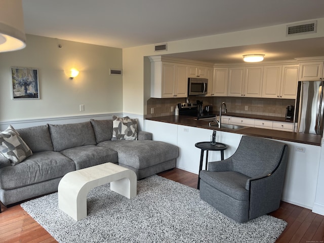 living area featuring visible vents and wood-type flooring