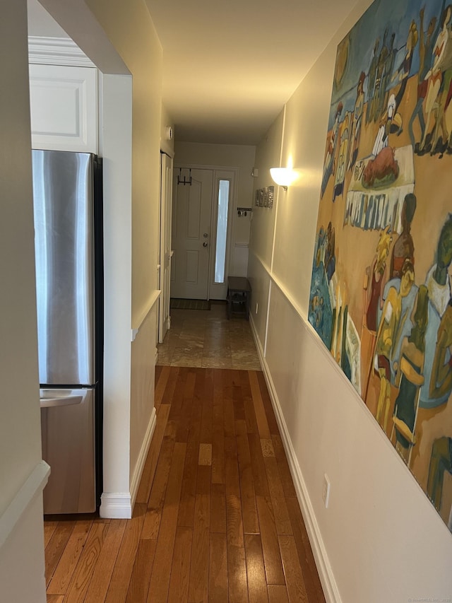 hallway featuring baseboards and hardwood / wood-style flooring