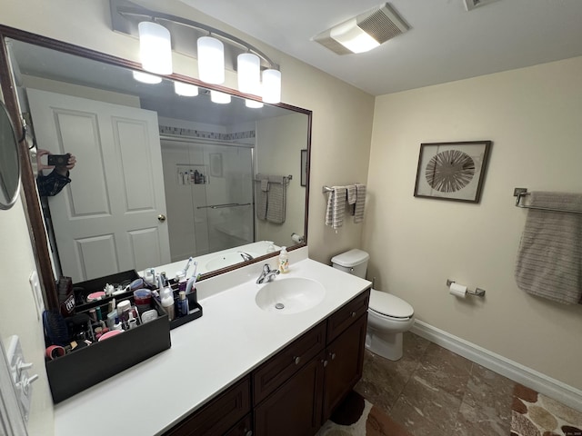 bathroom with a stall shower, toilet, vanity, baseboards, and visible vents