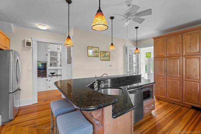 86 Tyler Ave, Groton, CT 06340 - kitchen with stainless steel appliances, a ceiling fan, a sink, light wood-style floors, and a kitchen island with sink