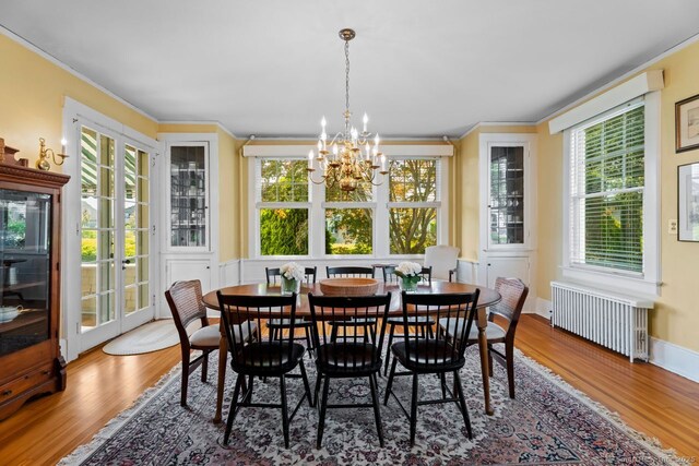 86 Tyler Ave, Groton, CT 06340 - dining space with radiator, a chandelier, wood finished floors, and crown molding