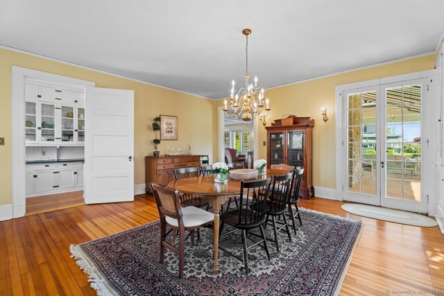 86 Tyler Ave, Groton, CT 06340 - dining room with a chandelier, wood finished floors, ornamental molding, and baseboards