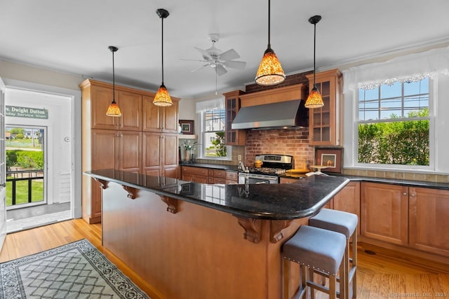 86 Tyler Ave, Groton, CT 06340 - kitchen featuring extractor fan, stainless steel gas range, light wood-style floors, and plenty of natural light