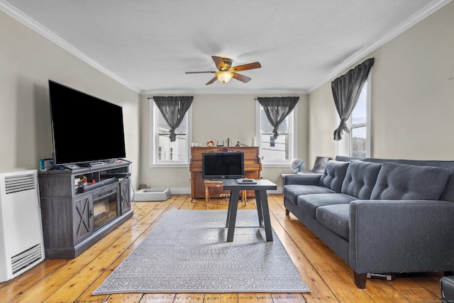 living room featuring baseboards, ceiling fan, ornamental molding, and light wood finished floors