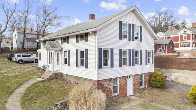 view of home's exterior with a chimney, entry steps, fence, and a yard