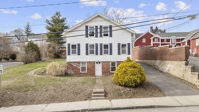 view of front of house with a front yard, fence, and brick siding