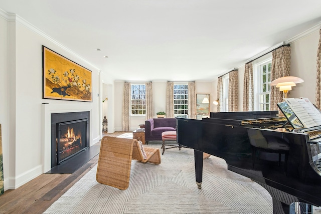 358 Lukes Wood Rd, New Canaan, CT 06840 - sitting room featuring wood finished floors, a warm lit fireplace, ornamental molding, and baseboards