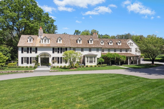 358 Lukes Wood Rd, New Canaan, CT 06840 - view of front of house with a front yard, a chimney, and curved driveway