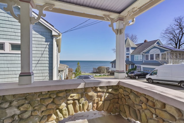 view of patio with a balcony and a water view
