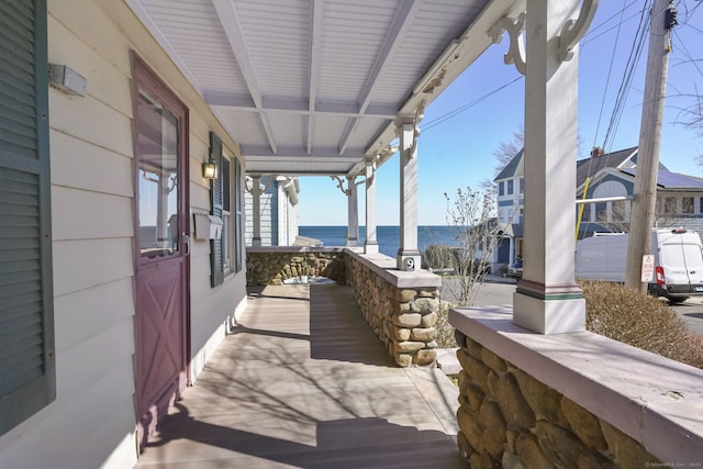 view of patio / terrace featuring covered porch and a water view