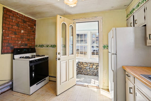 kitchen with light countertops, freestanding refrigerator, wooden ceiling, range with gas stovetop, and a baseboard radiator