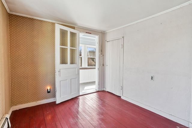 empty room with crown molding, a baseboard heating unit, hardwood / wood-style floors, baseboards, and wallpapered walls