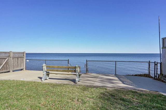 exterior space with a water view and fence