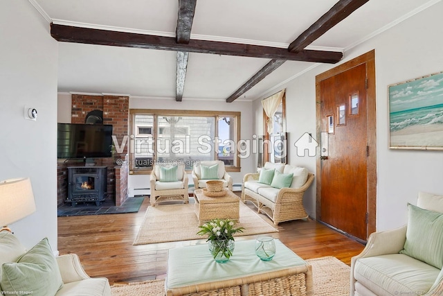 living room featuring a baseboard radiator, ornamental molding, wood finished floors, beam ceiling, and a wood stove