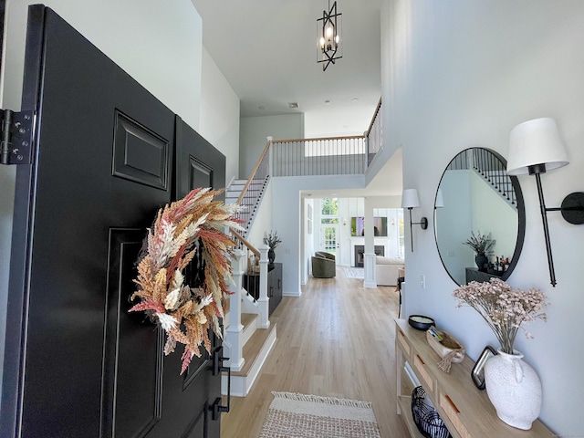 entrance foyer featuring a high ceiling, light wood-type flooring, and stairs