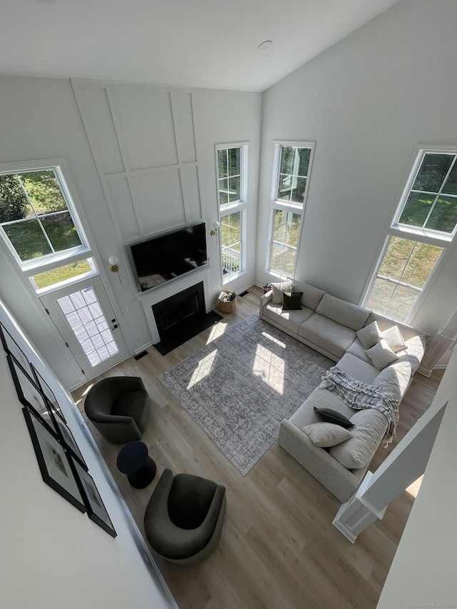 living room featuring a fireplace with flush hearth and wood finished floors
