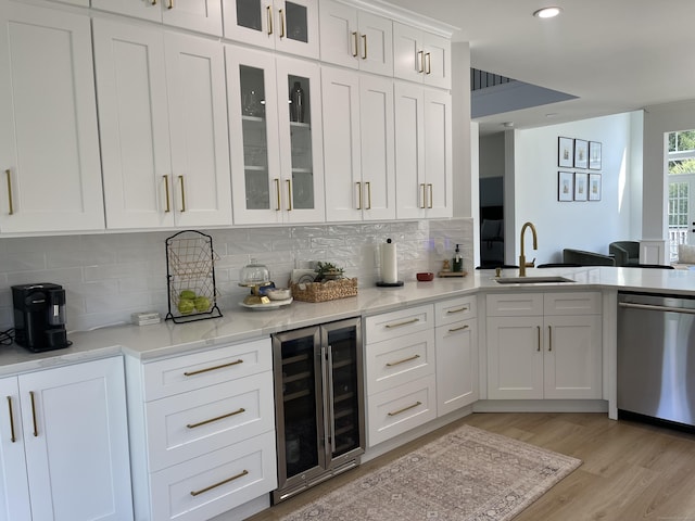 kitchen with stainless steel dishwasher, beverage cooler, a sink, and tasteful backsplash