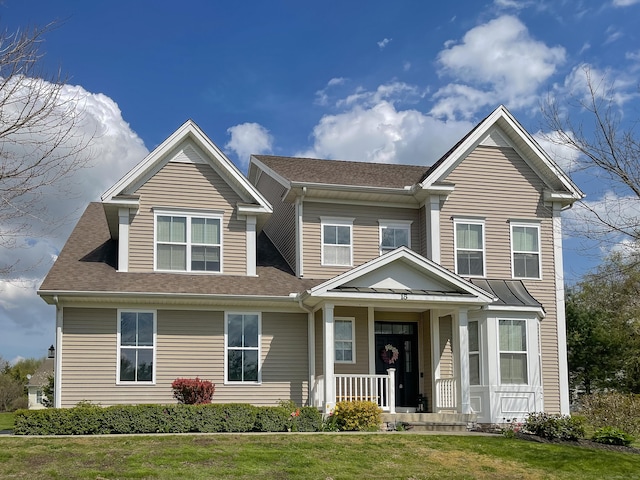 craftsman-style house with a porch, roof with shingles, and a front lawn