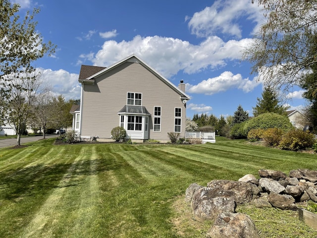 rear view of house with a lawn and a chimney