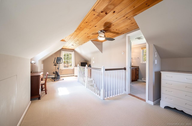 additional living space featuring a baseboard heating unit, baseboards, vaulted ceiling, and carpet flooring