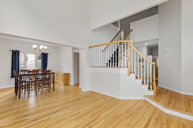 18 Catalpa St, Norwalk, CT 06851 - stairway with a chandelier, a high ceiling, wood finished floors, and baseboards