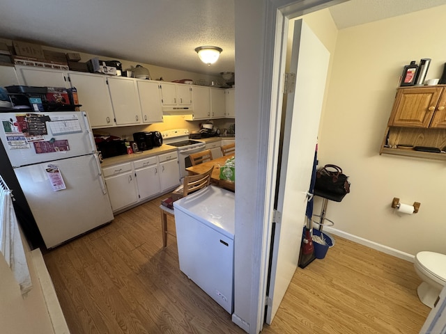 519 Scott Rd Apt 60, Waterbury, CT 06705 - kitchen with light countertops, light wood-style flooring, white appliances, under cabinet range hood, and white cabinetry