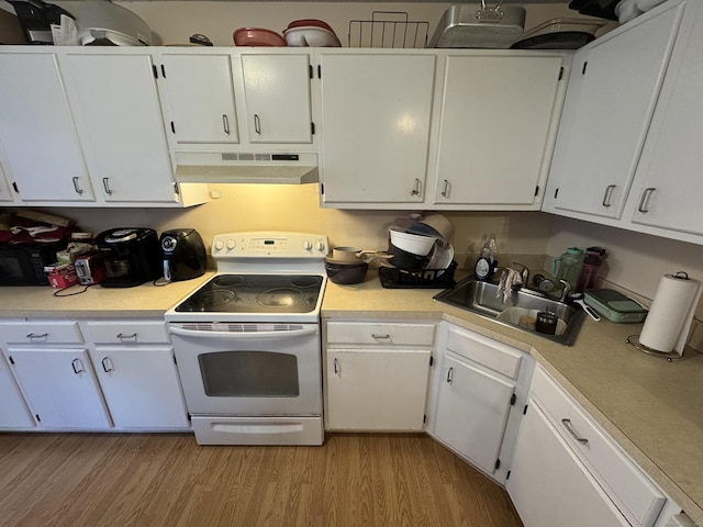 519 Scott Rd Apt 60, Waterbury, CT 06705 - kitchen featuring light countertops, under cabinet range hood, white range with electric cooktop, light wood-style floors, and white cabinets