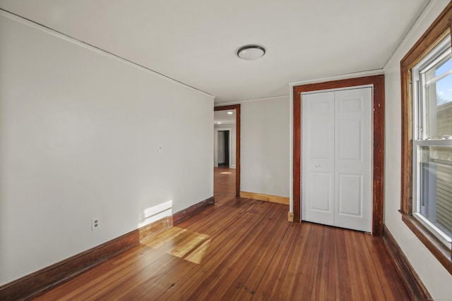 unfurnished bedroom featuring hardwood / wood-style flooring and baseboards