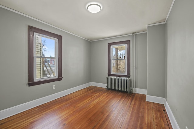 unfurnished room featuring baseboards, radiator, plenty of natural light, and dark wood finished floors