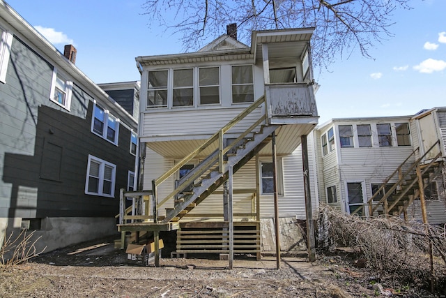 back of house featuring stairs and a chimney