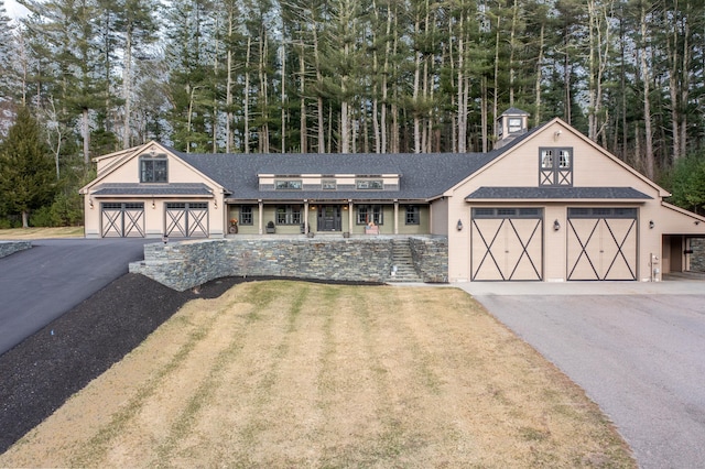 view of front of home featuring an outbuilding, aphalt driveway, a front yard, a barn, and a garage