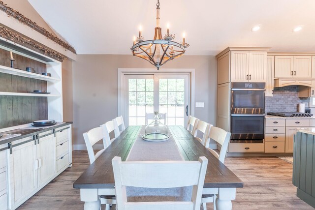 dining area with light wood-style floors, an inviting chandelier, vaulted ceiling, and recessed lighting