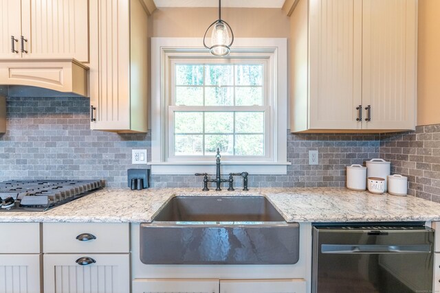 kitchen featuring tasteful backsplash, dishwasher, a sink, hanging light fixtures, and black cooktop