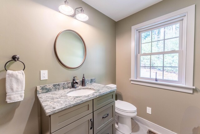bathroom with toilet, tile patterned floors, vanity, and baseboards