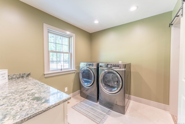 clothes washing area featuring baseboards, a barn door, laundry area, recessed lighting, and washing machine and clothes dryer