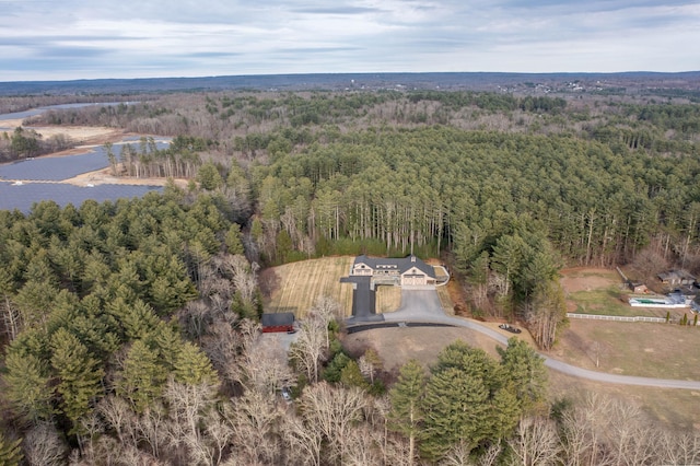 aerial view featuring a wooded view and a water view
