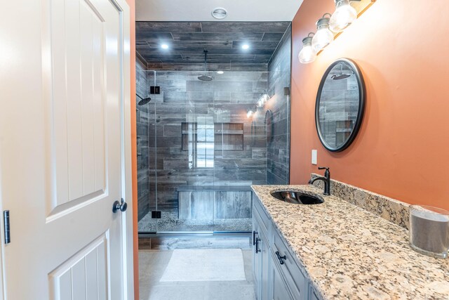 bathroom featuring tiled shower and vanity
