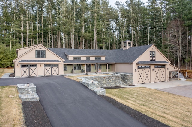 view of front facade with driveway and a shingled roof