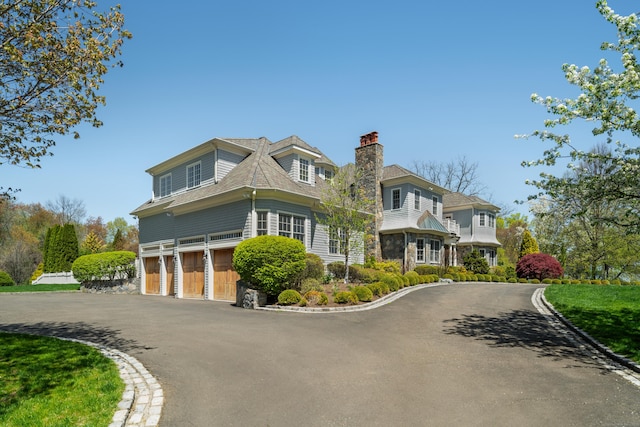 355 Greens Farms Rd, Westport, CT 06880 - view of front of home featuring a chimney, an attached garage, driveway, and stone siding