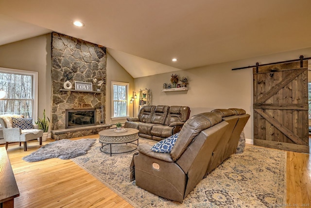 110 Far Mill Dr, Stratford, CT 06614 - living room with wood finished floors, a fireplace, lofted ceiling, and a barn door