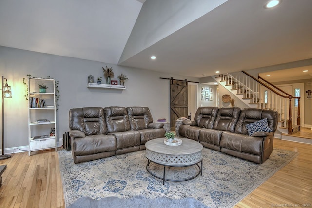 110 Far Mill Dr, Stratford, CT 06614 - living room featuring a barn door, recessed lighting, vaulted ceiling, wood finished floors, and stairs