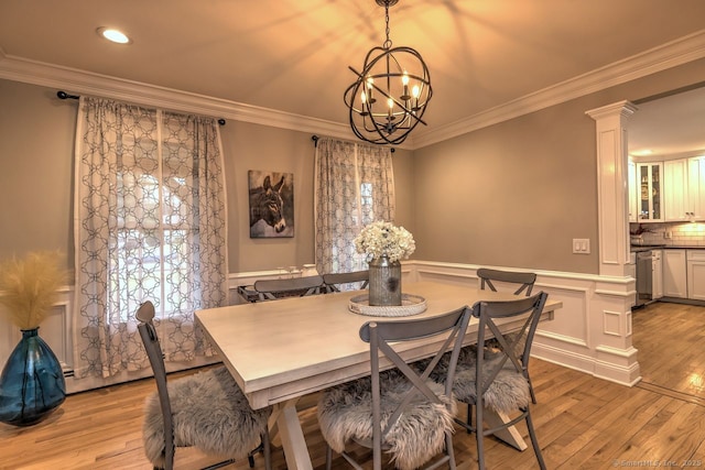 110 Far Mill Dr, Stratford, CT 06614 - dining area with light wood-style floors, a notable chandelier, ornamental molding, and wainscoting