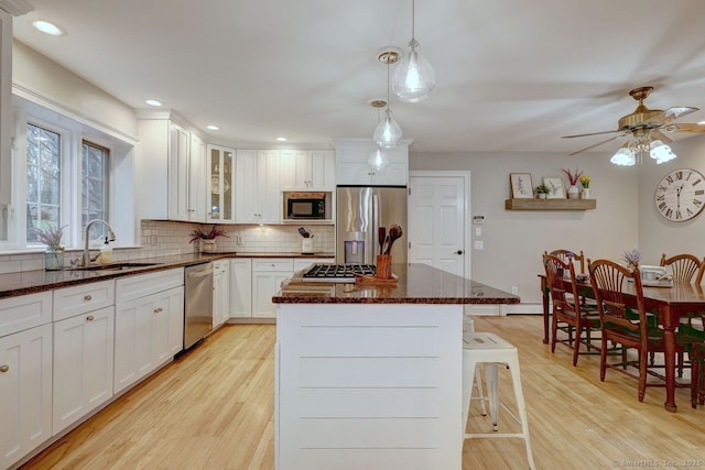 110 Far Mill Dr, Stratford, CT 06614 - kitchen featuring light wood-style floors, a center island, decorative backsplash, and appliances with stainless steel finishes