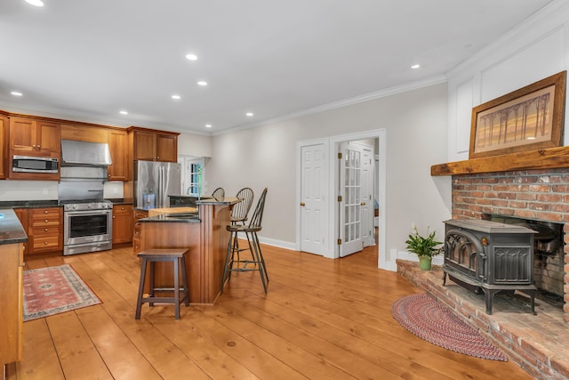 6 Ely Ln, Killingworth, CT 06419 - kitchen with stainless steel appliances, extractor fan, a wood stove, crown molding, and a breakfast bar area