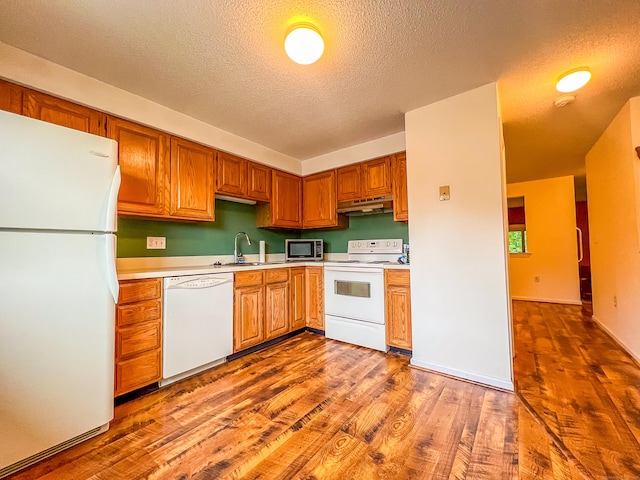 1516 E Main St Apt 18, Meriden, CT 06450 - kitchen featuring white appliances, under cabinet range hood, a sink, light countertops, and a textured ceiling